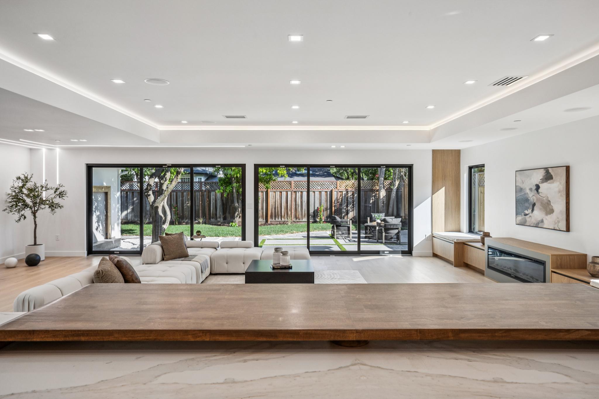 Panoramic indoor-outdoor living great room in a San Jose custom home, featuring multi-slide glass doors that open completely to the backyard, designed by Ritz Builders.