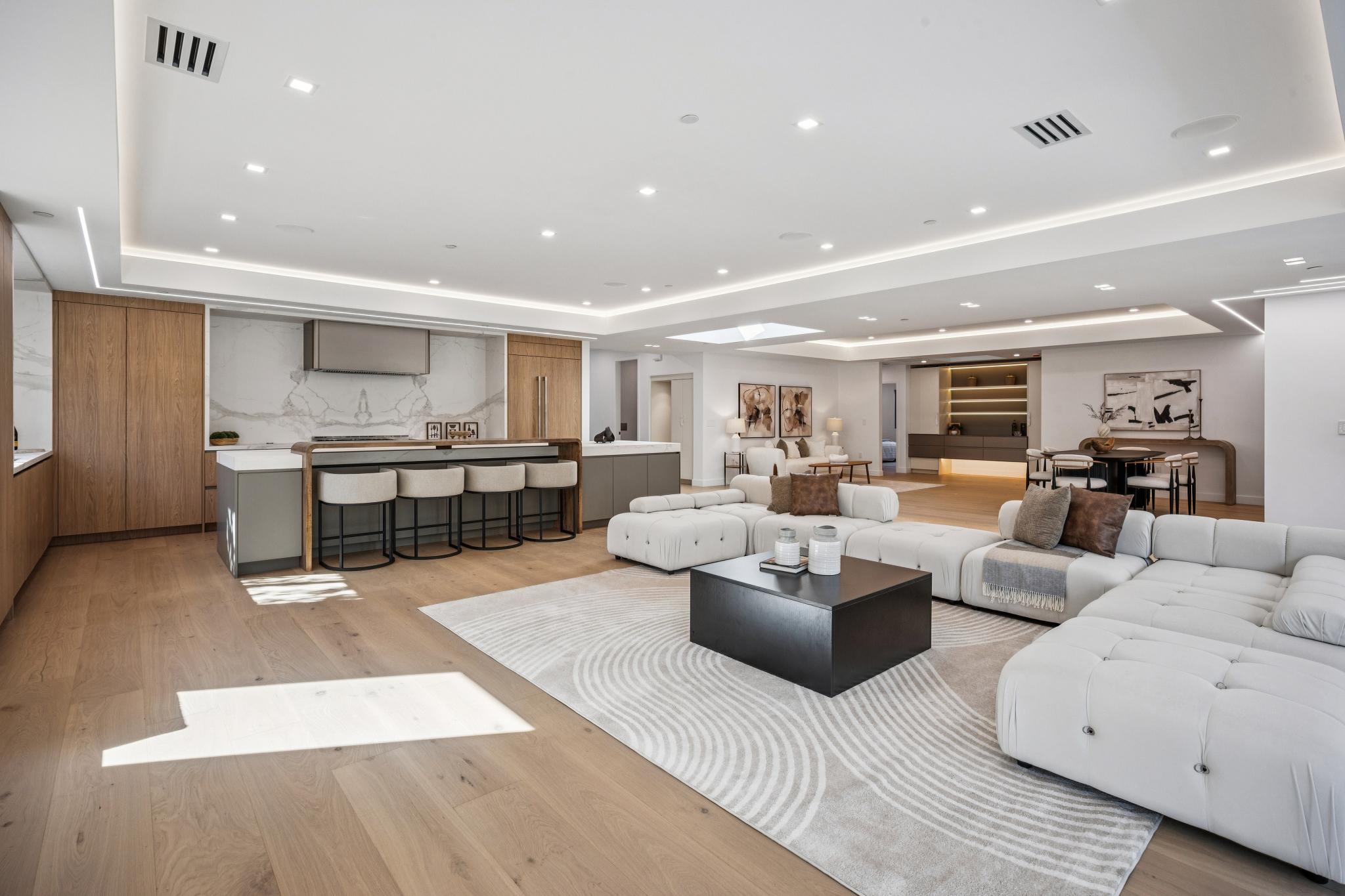Expansive luxury living area and great room layout in a custom San Jose home, showcasing premium wide-plank light hardwood flooring and high-end contemporary interior architecture.