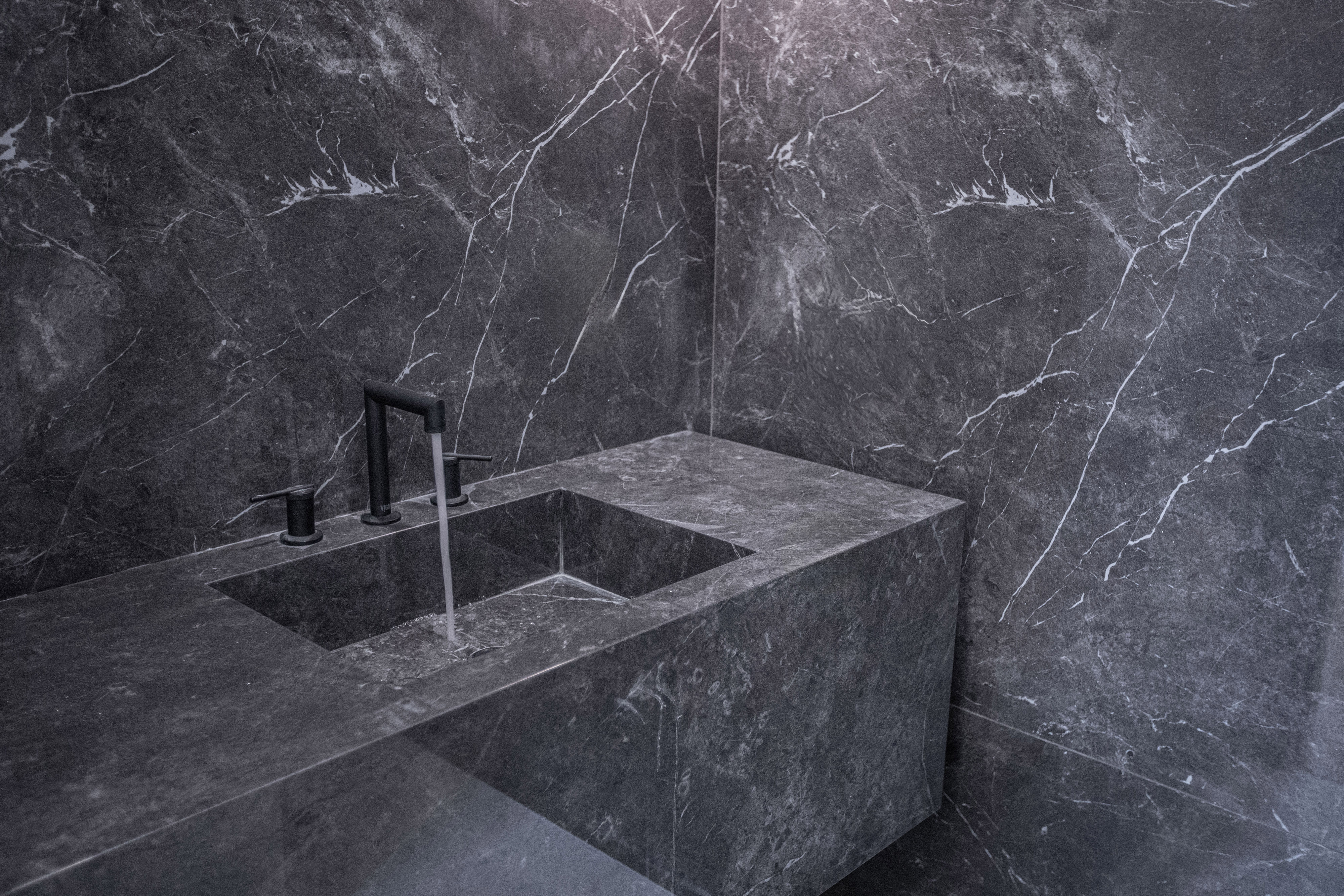 Close-up of a custom monolithic stone sink demonstrating elite specialty trade coordination and precise craftsmanship.